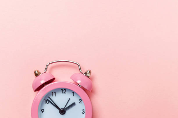 istock Vintage alarm clock Isolated on pink pastel background 1131026656