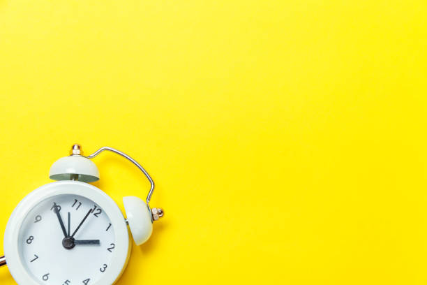 istock Vintage alarm clock Isolated on yellow background 1131027381