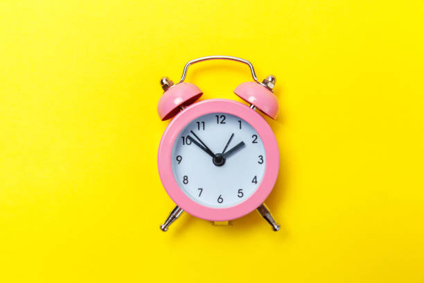 istock Vintage alarm clock Isolated on yellow background 1131027391