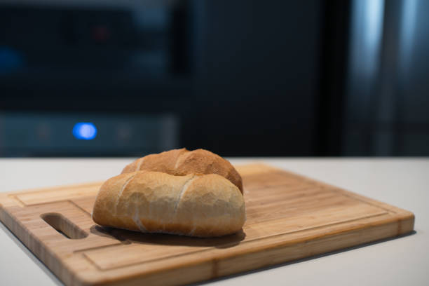 French Bread on a wood cut board against a modern kitchen blurred background