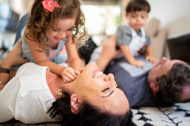 istock Twin Sibling (Down Syndrome Son and Daughter) tickling parents at home 1131027939
