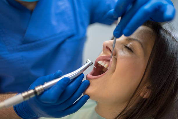 istock Dentist with protective mask and gloves repair tooth 1131028665