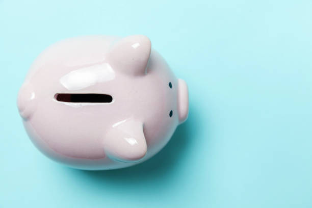 istock Pink piggy bank isolated on blue background 1131028675