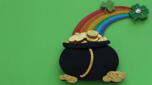 istock Black pot of gold under a rainbow on green background 1131032660