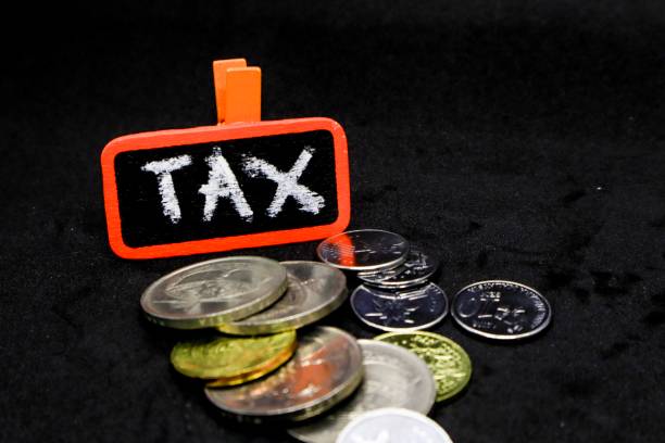 istock The word “TAX” written using chalk on a small board with black background and scattered coins 1131032825