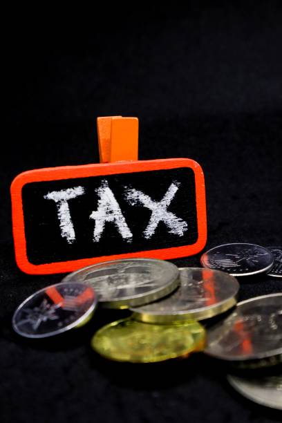 istock The word “TAX” written using chalk on a small board with black background and scattered coins 1131032832