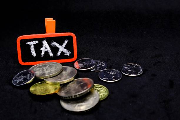 istock The word “TAX” written using chalk on a small board with black background and scattered coins 1131032837