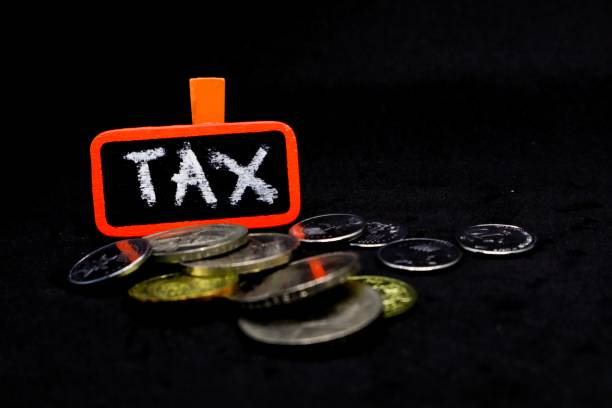 istock The word “TAX” written using chalk on a small board with black background and scattered coins 1131032859
