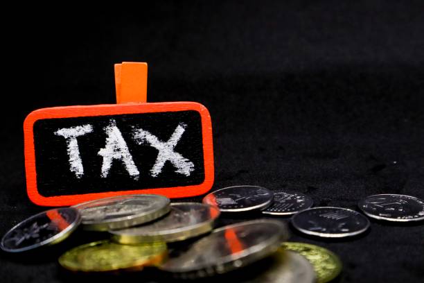 istock The word “TAX” written using chalk on a small board with black background and scattered coins 1131032861