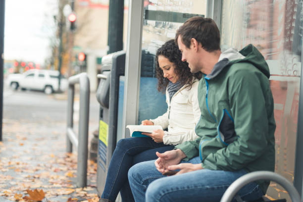 istock Two friends waiting for the bus at a city stop 1131037030