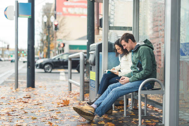 istock Two friends waiting for the bus at a city stop 1131037034