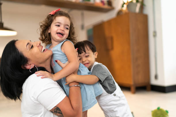 Mother and Twin (Down Syndrome Son and Daughter) embracing at home