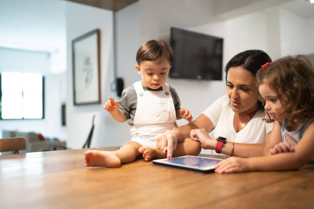 bliźniacze rodzeństwo (syn i córka zespołu downa) i matka używająca tabletki w domu - ipad baby boys little boys caucasian zdjęcia i obrazy z banku zdjęć