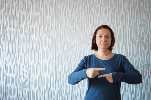 língua de sinal americana, mulher que mostra o sinal do termo - deaf american sign language hand sign human hand - fotografias e filmes do acervo