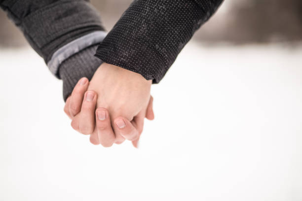 istock Young couple holding hands on a winter day close up. 1131042927
