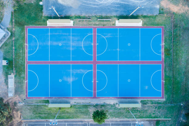istock Looking down at new blue netball courts - aerial view 1131043235