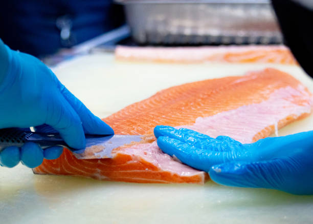 istock chef slicing raw fresh salmon, Chef preparing a fresh salmon on a cutting board 1131046466