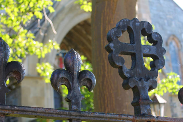 Chincoteague Island, Virginia, USA - March 21, 2024: A well-weathered, ornate wrought iron gate and fence surrounding a historic cemetery in the Town of Chincoteague.