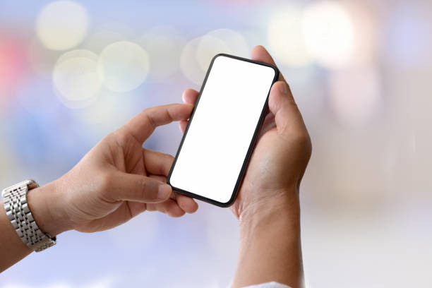 istock Blank screen mobile smart phone in male hand over light bokeh background 1131047977