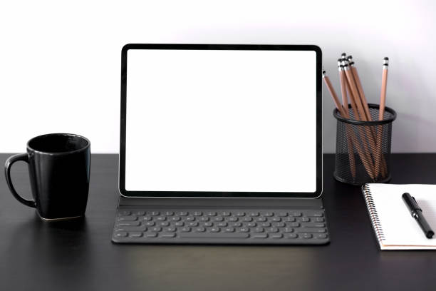 istock Tablet with smart keyboard case with blank screen on dark wood table 1131049689