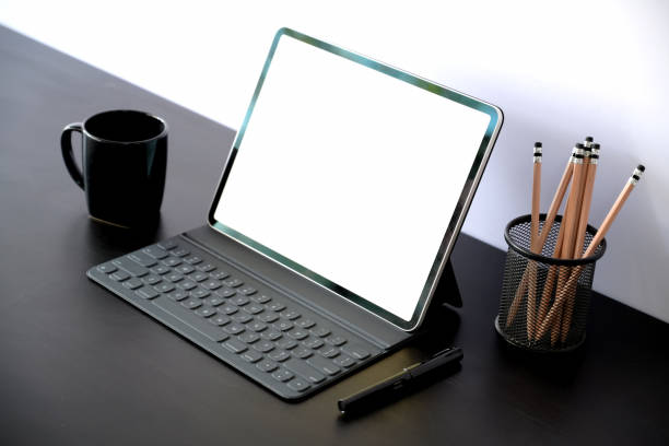 istock Tablet with smart keyboard case with blank screen on dark wood table 1131049692