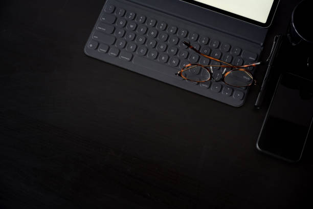 istock Office dark wood workspace with tablet, office supplies and copy space 1131049709