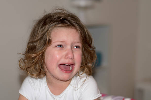 Sad crying caucasian little girl looking away