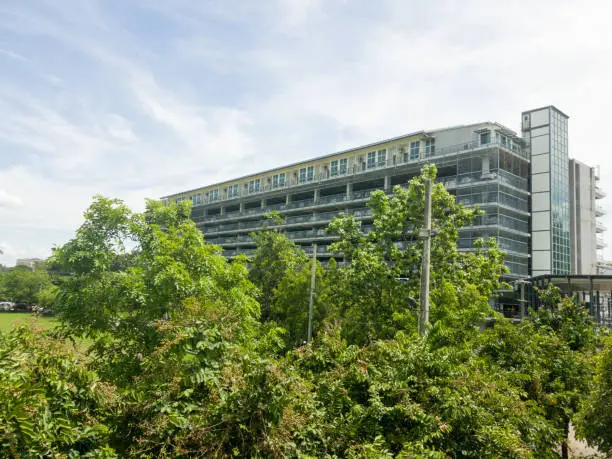 Photo of big parking building at among many trees