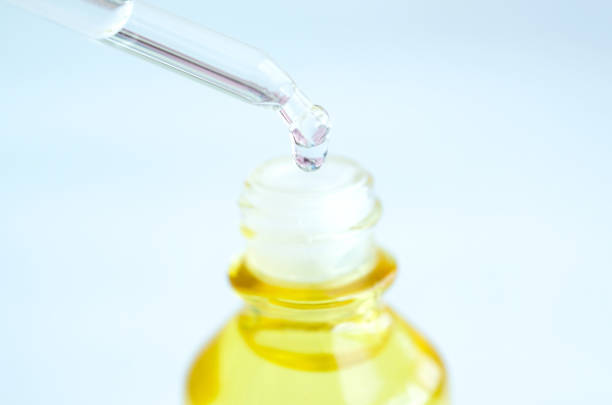 istock Dropping serum collagen moisturizer of face into clear yellow bottle soft light background. Protector skin Treatment facial essence oil, Vitamin C. Beauty and spa Concept. 1131057460