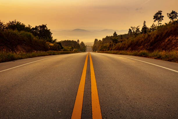 istock asphalt highway and morning sun light in thailand 1131057642