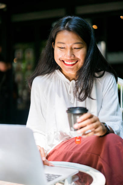 istock Smiling Indonesian woman using her laptop 1131057681
