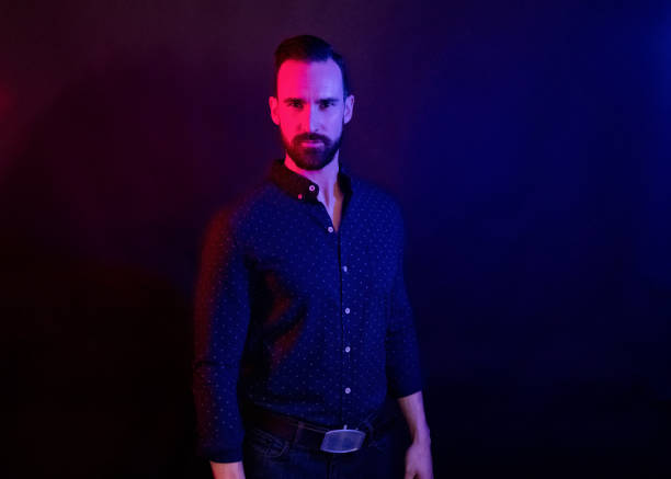istock Handsome man with blue shirt with color lighting 1131060388