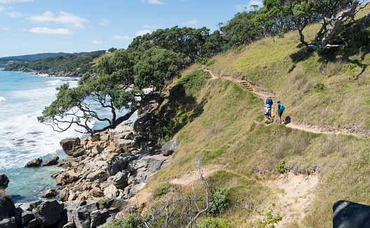 Multi-generation family group enjoy a day hike on a coastal walkway with stunning views of the ocean