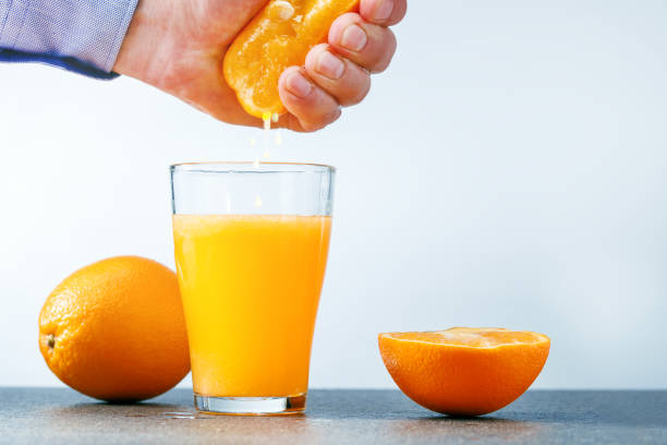 istock Man making healthy organic orange juice in kitchen 1131062615