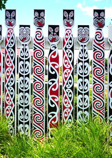 Fence with traditional Maori faces Fence with traditional Maori faces koru pattern stock pictures, royalty-free photos & images