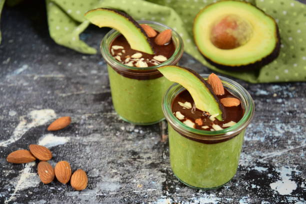 Gélose à la gelée d'avocat avec sauce au chocolat et noix d'amande hachée dans des pots en verre - Photo