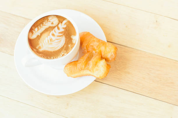 istock hot coffee with deep-fried dough stick / coffee with deep-fried dough stick on wood table 1131074501