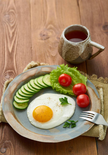 istock Fried egg, vegetables. Paleo, keto, fodmap diet. Copy space, top view, vertical. Healthy diet concept, blue plate on old rustic wooden table 1131075661
