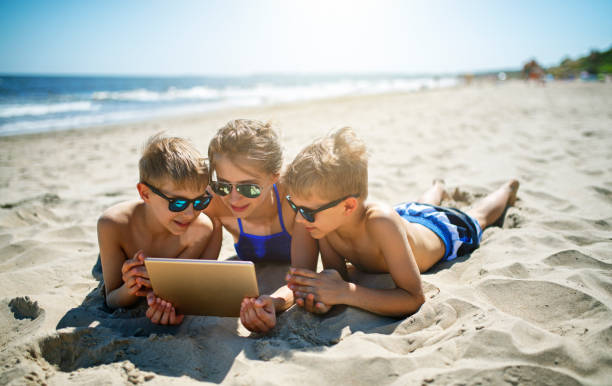 bambini in spiaggia con tablet - china sea foto e immagini stock
