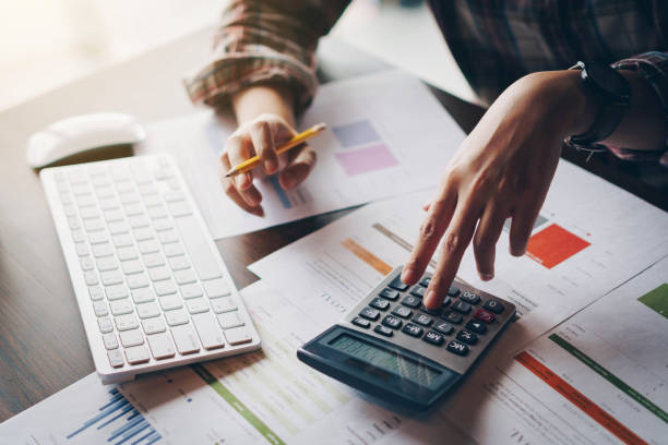 istock Businesswoman analyzing financial reports with calculator and  typing on modern computer keyboard at office. Business analytics concept. Accounting and technology in office. 1131078629
