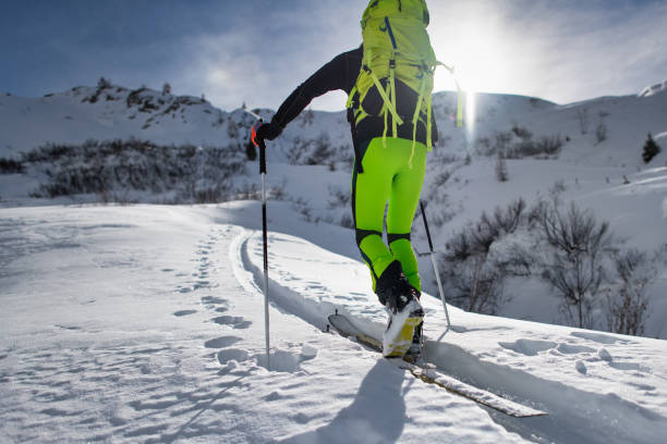 kletterer mit bergski geht auf eine ausgetretenen spur - telemark skiing stock-fotos und bilder