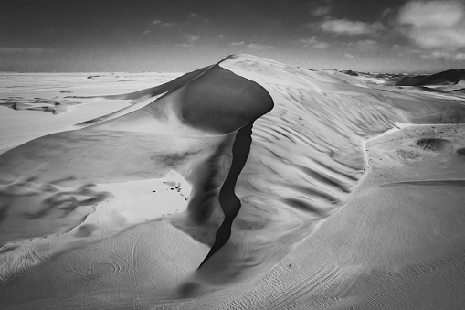 Aerial view of huge Desert Sand Dune close to Walvis Bay - Swakopmund, Dorob National Park - Namib-Naukluft Park, Namibia, South West Africa. Edited Black and White Scenic Panorama.