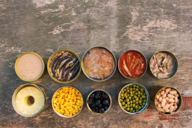 istock Different open canned food on old wooden background. Top view. Flat lay. 1131084891