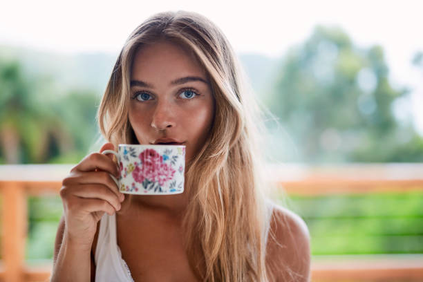 mädchentrinken aus teetasse - blaue augen stock-fotos und bilder