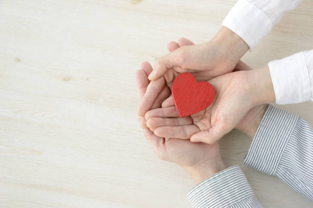 istock Heart object covered by man and woman's hands 1131094484