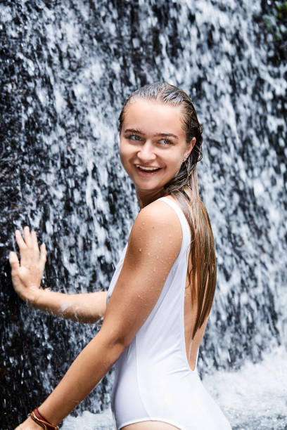 istock Swimsuit girl under waterfall 1131094704