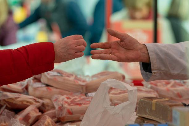 paying the butcher for fresh meat