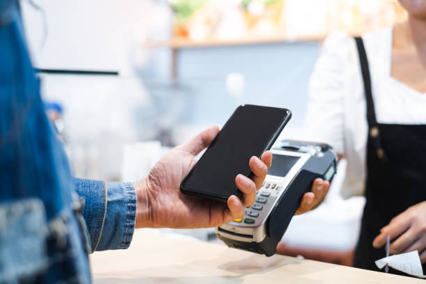 istock Customer using mobile phone scanning for payment to owner at cafe restaurant, cashless technology and credit card payment concept 1131097478