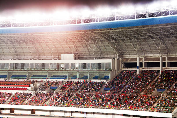 istock Audience watching soccer game in stadium at night 1131098357