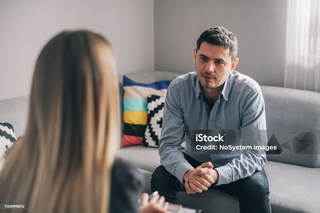 Young man, alcoholic, on  therapy session Young man, alcoholic, talking to female therapist about his problems, on  therapy session Addiction Stock Photo